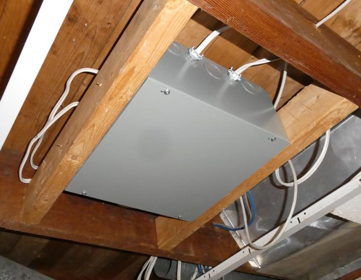 Image of bedroom control box mounted in basement ceiling, closed with wires feeding through sides